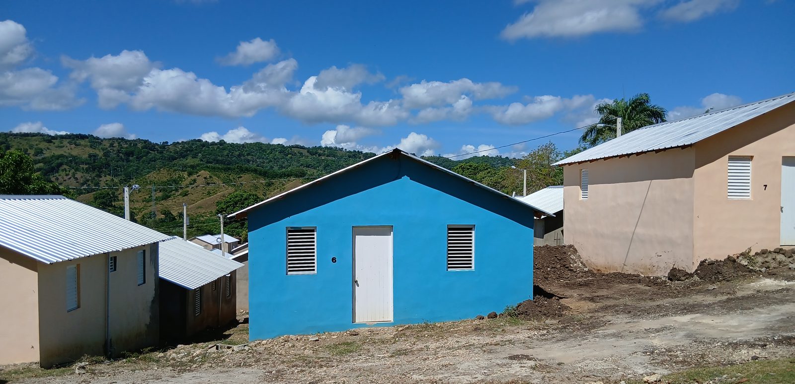 Casas terminadas de Villa Gracia, una pintada de azul, con las lomas al fondo